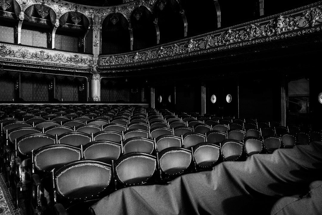 Empty ornate vintage theater with rows of seats and balconies
